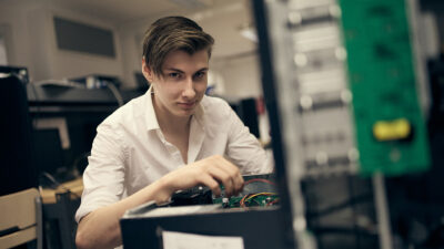 Elev som kollar sladdarna på en stationär dator