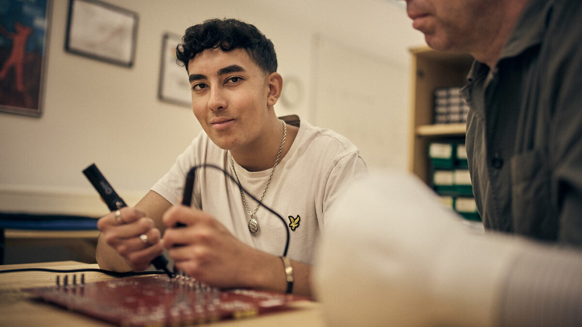 Elev som löder på ett kretskort