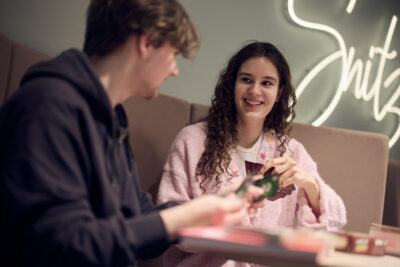 Två elever spelar glatt kortspel tillsammans.