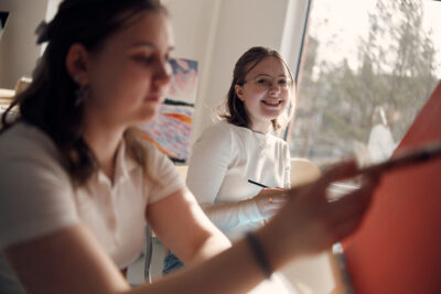 Glada elever som målar tavlor.