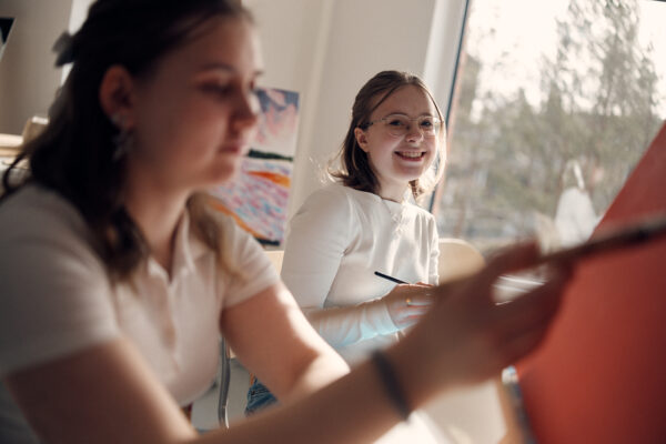 Glada elever som målar tavlor.