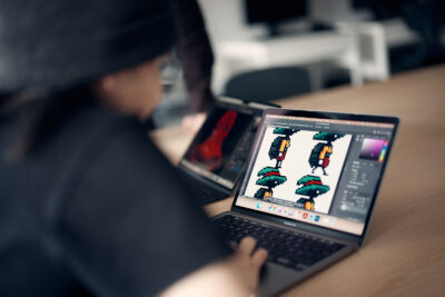 Elev framför stationär dator som designar figurer till spel.