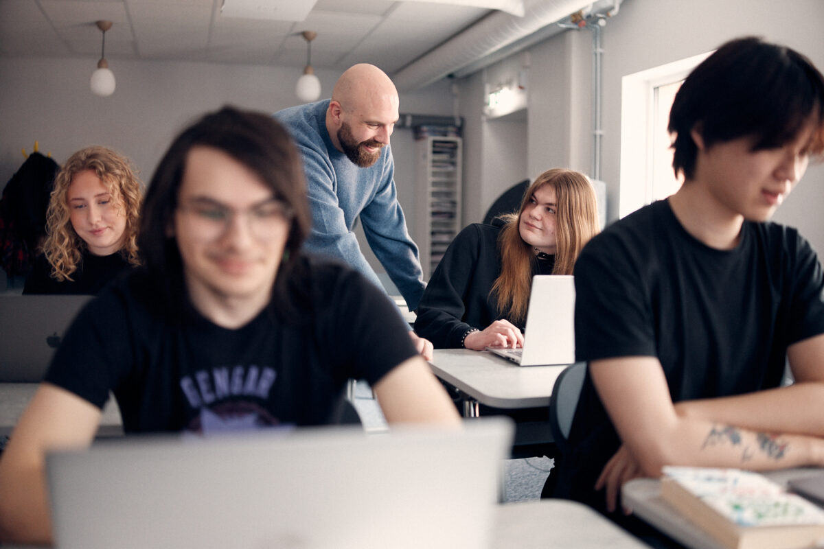 Lärare som hjälper elev i klassrummet.